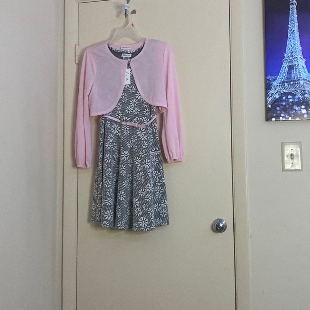 Black and white dress with flowers and a pink belt and pink sweater